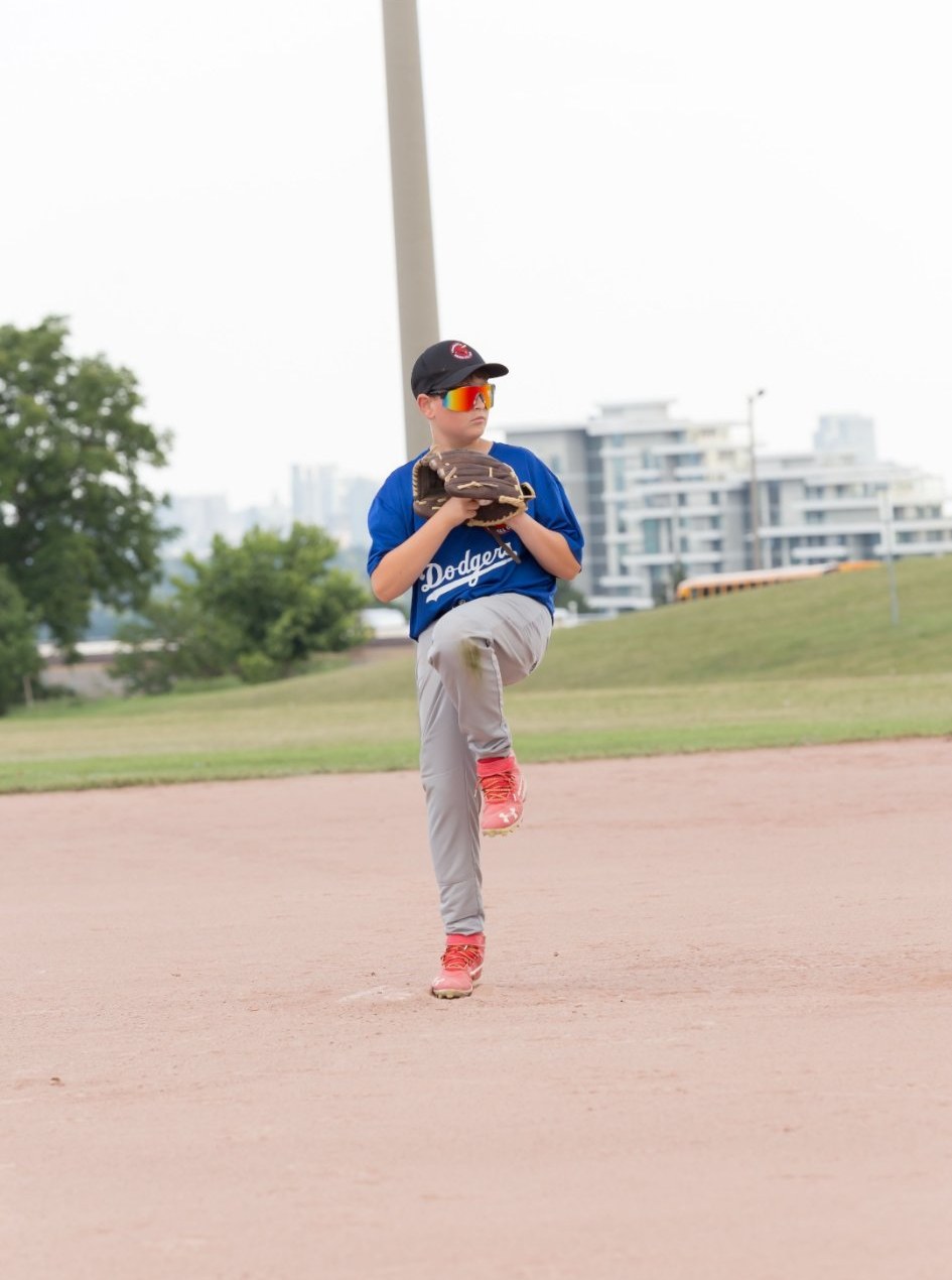 Young pitcher at peak leg kick, real game