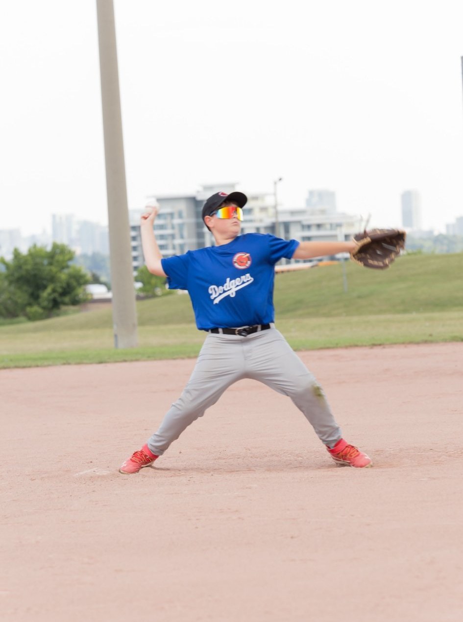 Young pitcher in full follow-through, real game